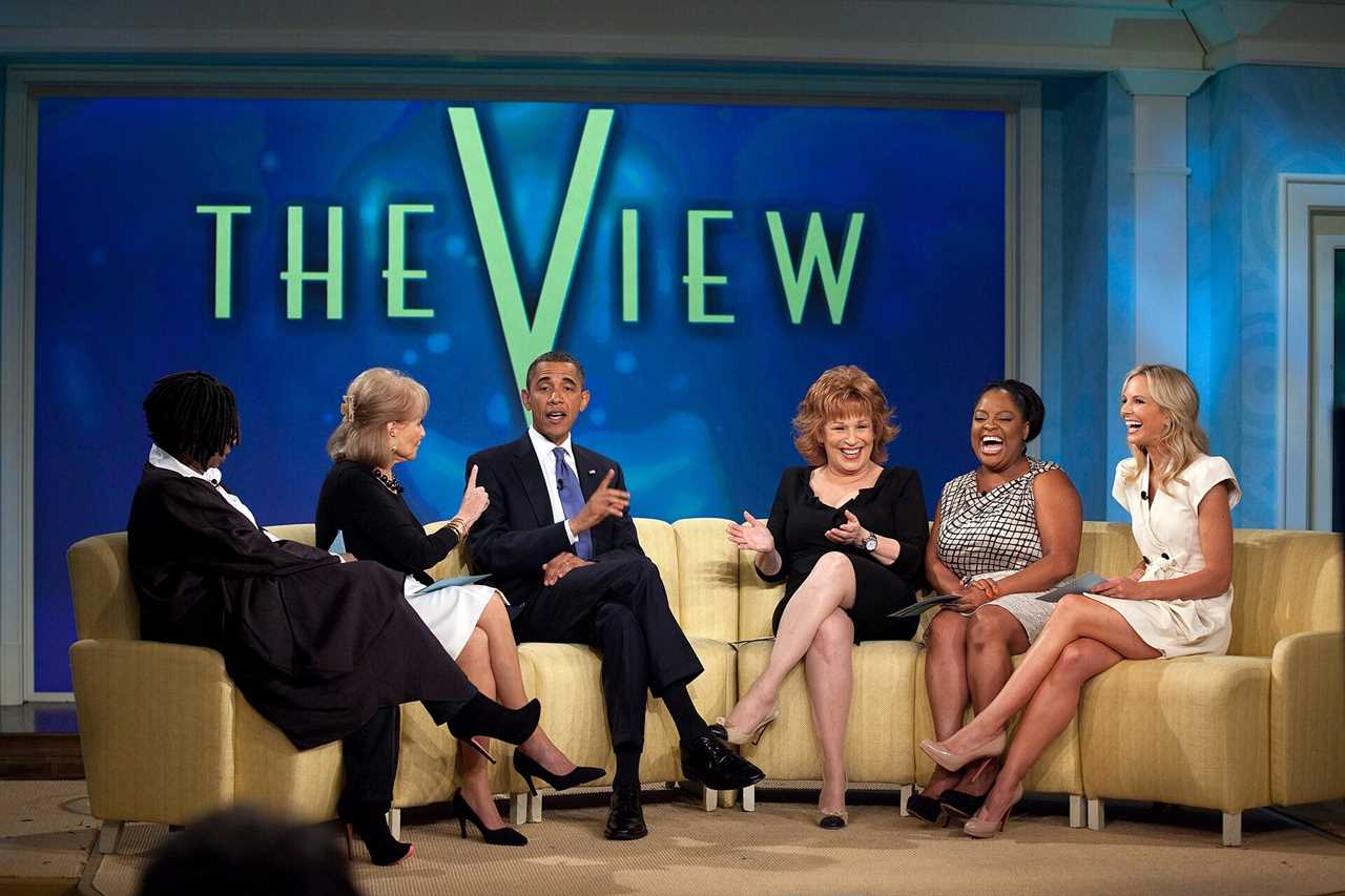 Barack Obama appears on The View, engaging with the hosts in a lively discussion while seated on a yellow couch.