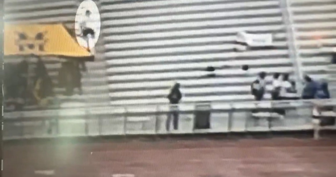 A view of empty stadium bleachers with a few spectators gathered, showcasing the atmosphere of a sports event.