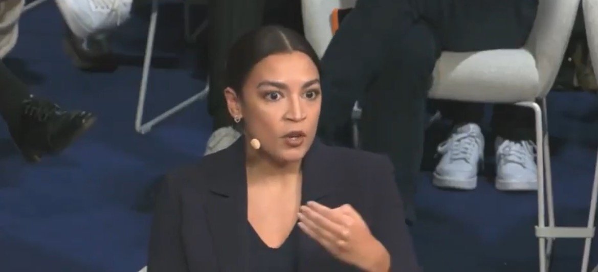 Politician speaking passionately during a panel discussion, emphasizing key issues while engaging with the audience in a professional setting.